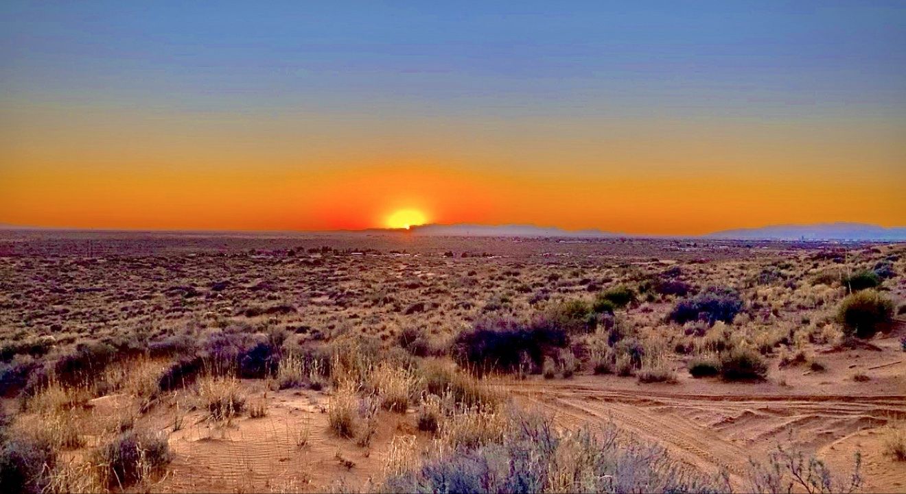 A vivid sunset stretching across the Red Sands desert